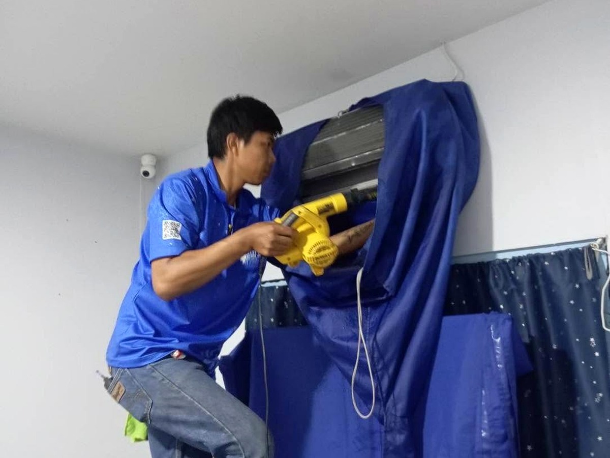 ช่างกำลังประกอบเครื่องปรับอากาศหลังล้าง